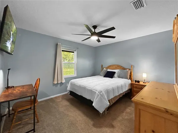 a bedroom with a bed and a chandelier with a flat tv screen