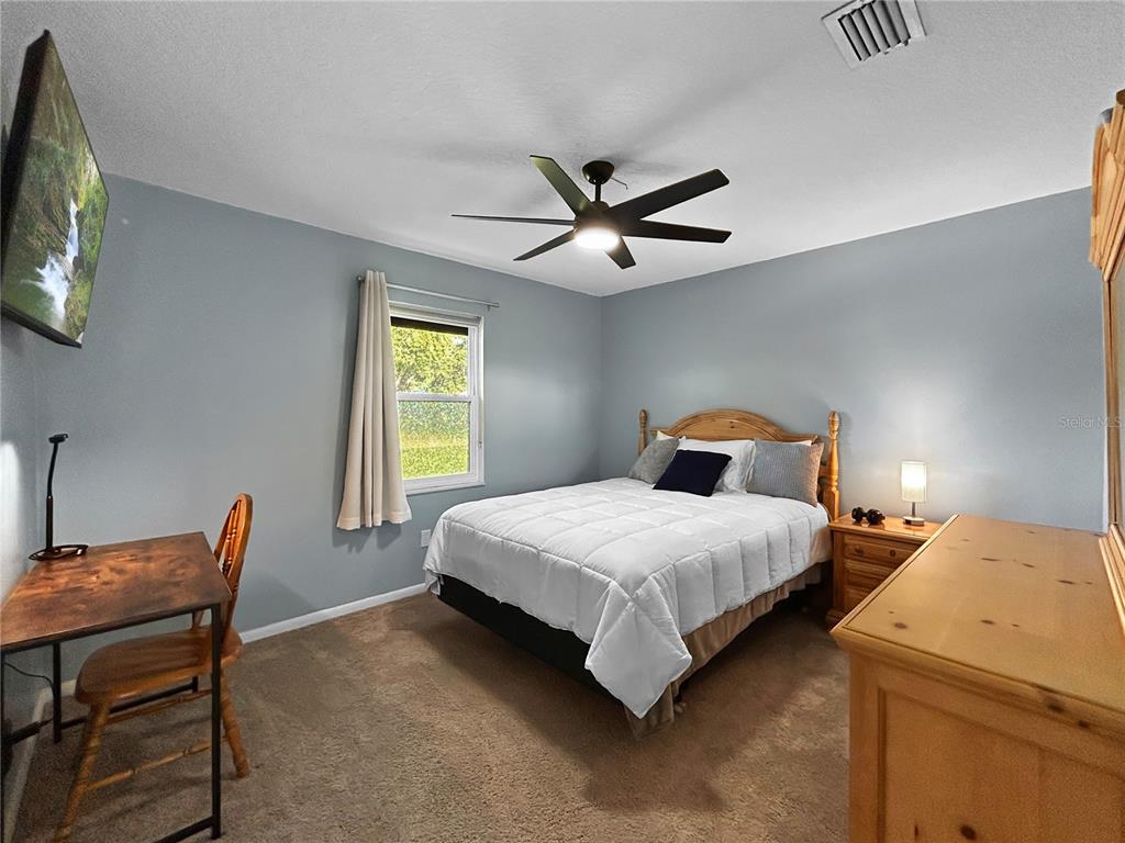 136 Paul Revere Road Bartow, FL 33830 - Photo 10 of 17 a bedroom with a bed a chandelier and a chair