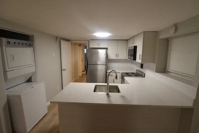 a kitchen with refrigerator and chairs