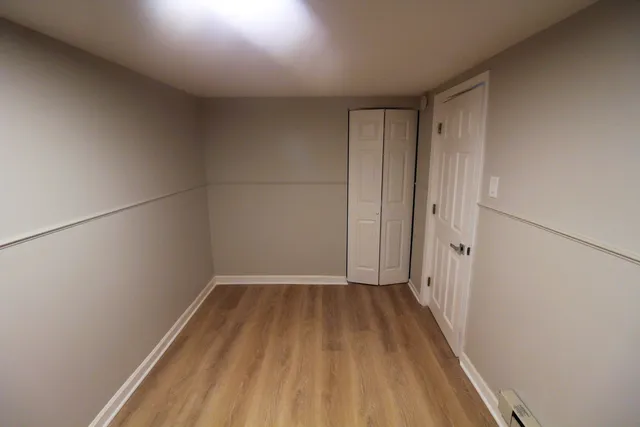 a view of a room with wooden floor and white walls