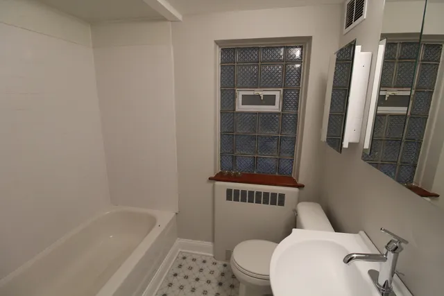 a white toilet sitting next to a bath tub