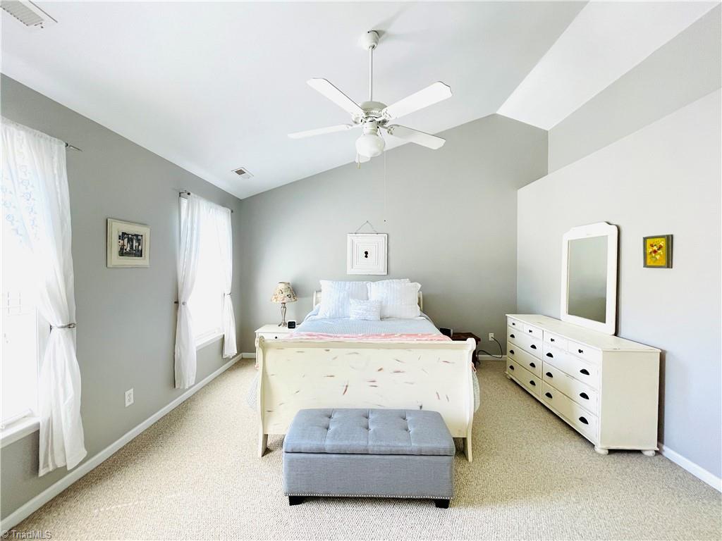 7818 Wilson Farm Road Summerfield, NC 27358 - Photo 20 of 50 Primary bedroom with plenty of natural light and vaulted ceiling