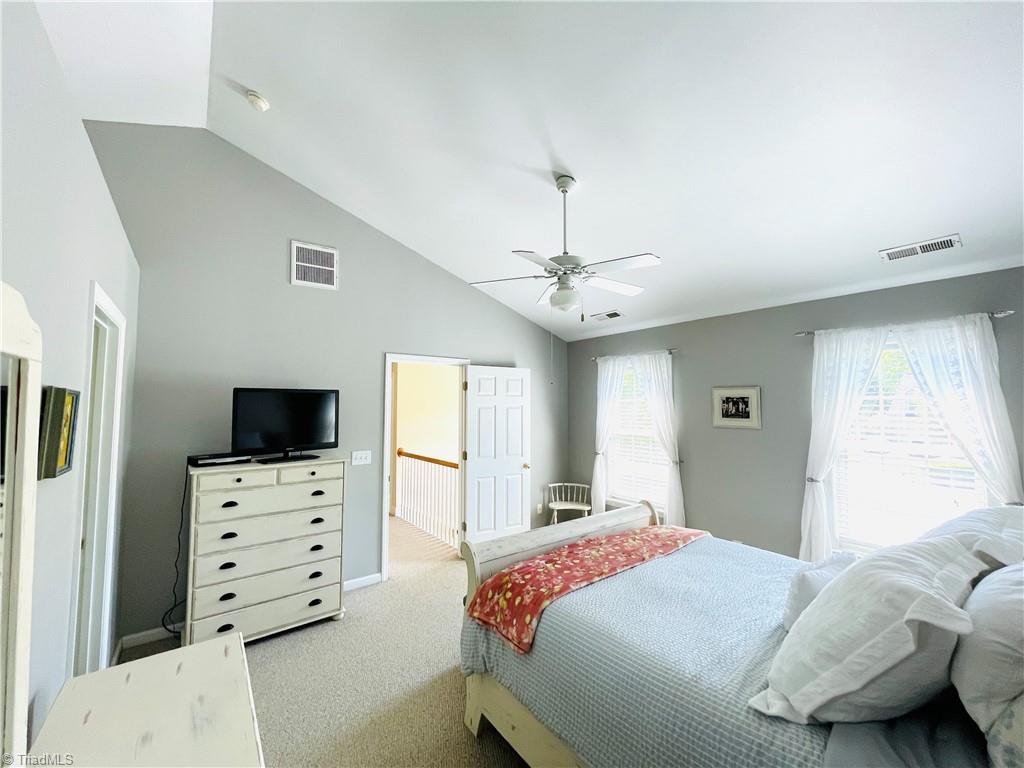 7818 Wilson Farm Road Summerfield, NC 27358 - Photo 21 of 50 Primary bedroom with vaulted ceiling and plenty of natural light