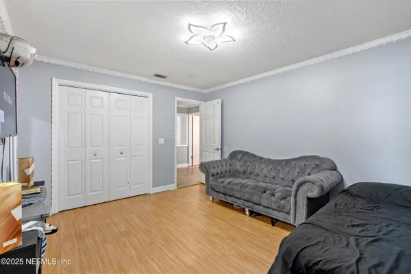 a bedroom with a bed and wooden floor