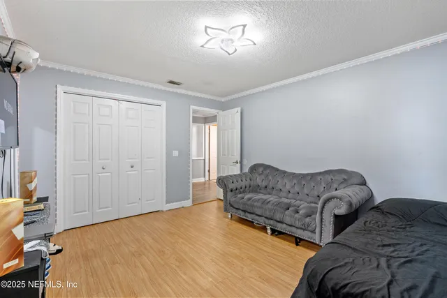 a bedroom with a bed and wooden floor