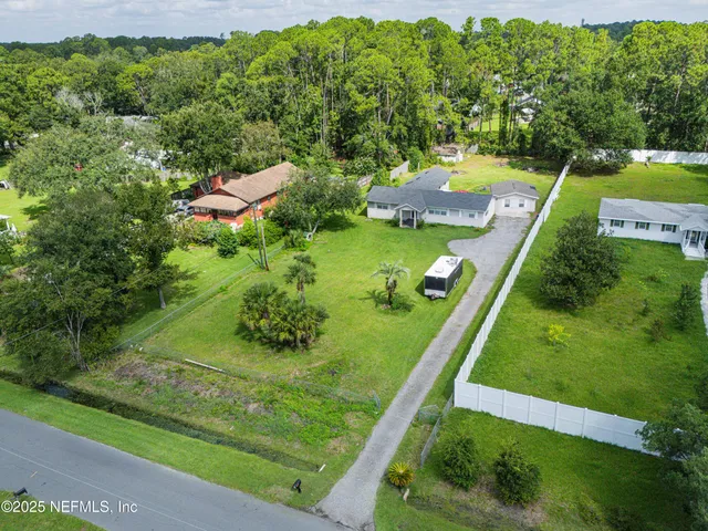 a view of a house with a yard and potted plants