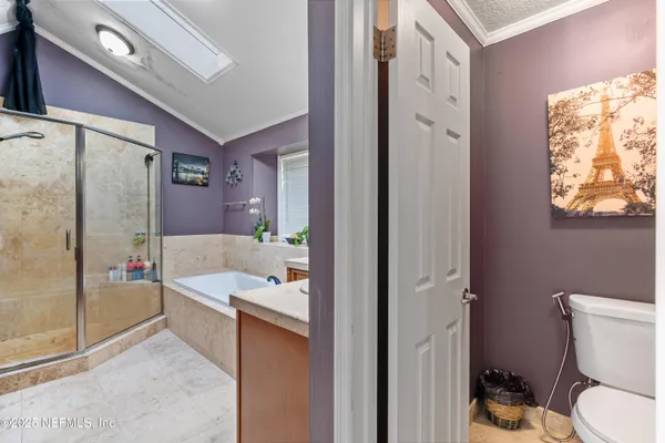 a bedroom with a large bed chandelier and a window
