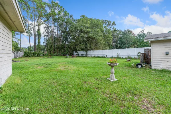 a backyard of a house with plants and large trees