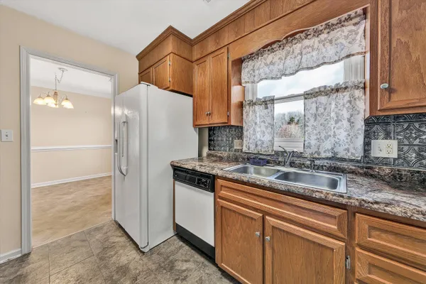 a large kitchen with stainless steel appliances granite countertop a stove a sink and a refrigerator