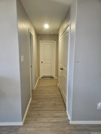 a view of a hallway with wooden floor