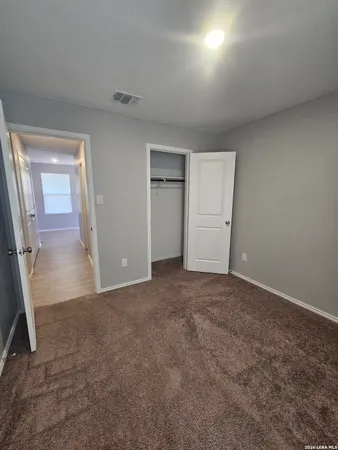 an empty room with closet and mirror