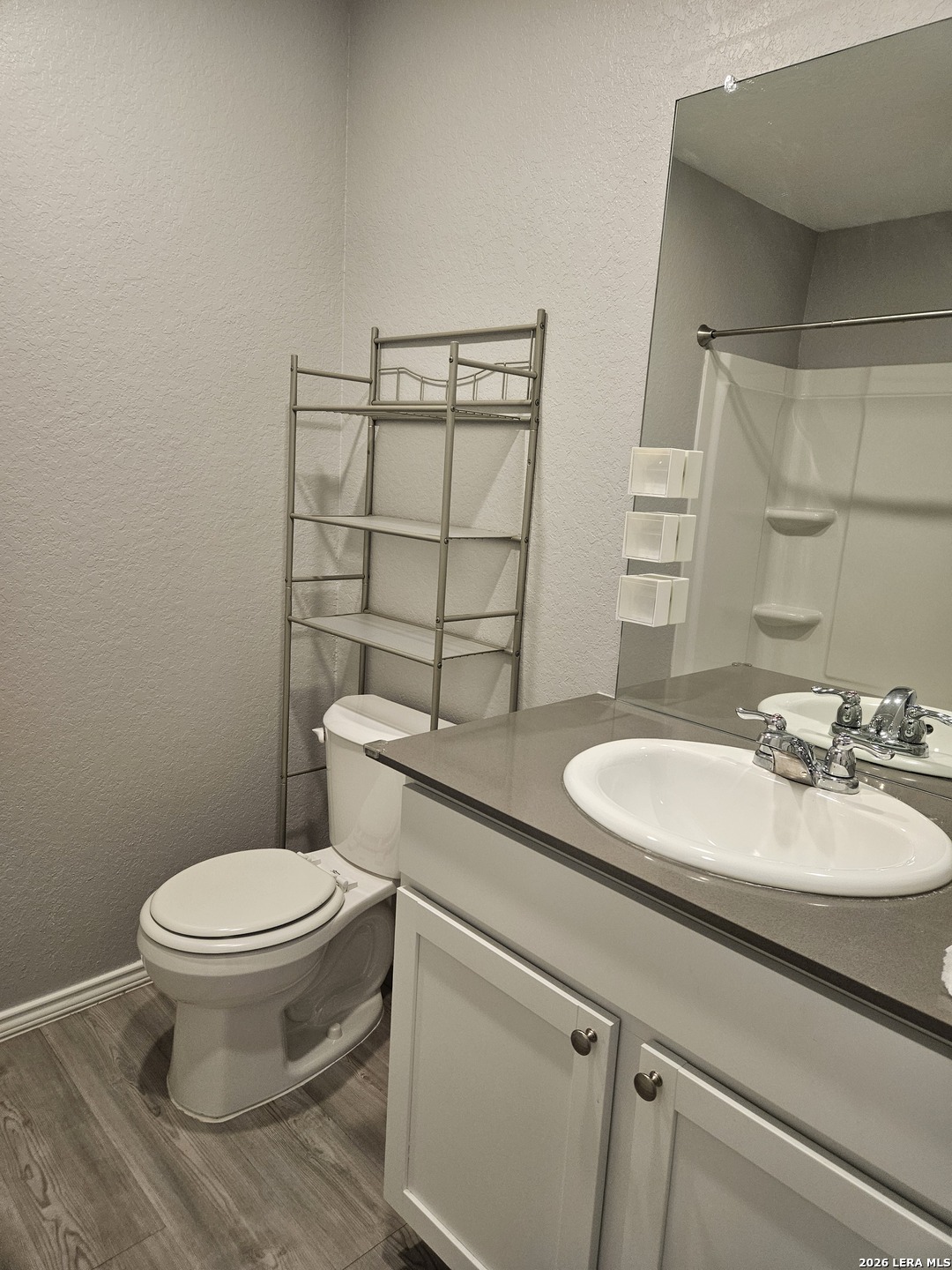 6855 Burgess Ridge Converse, TX 78109 - Photo 19 of 24 a bathroom with a granite countertop toilet sink and mirror