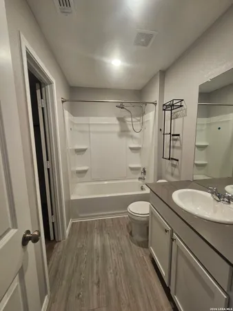 a bathroom with a sink a toilet a tub and shower