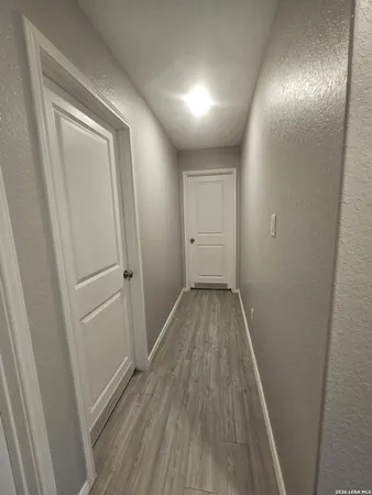a view of a hallway with wooden floor