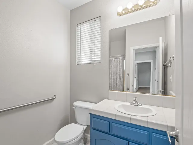 a bathroom with a toilet a sink and mirror