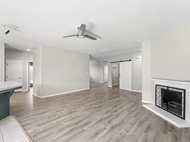 a view of empty room with wooden floor and fireplace