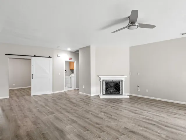 a view of an empty room with a fireplace and a window