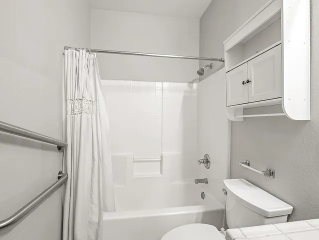 a bathroom with a toilet and a shower