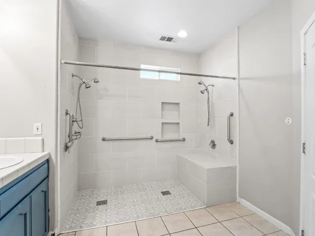 a spacious bathroom with a sink and a mirror