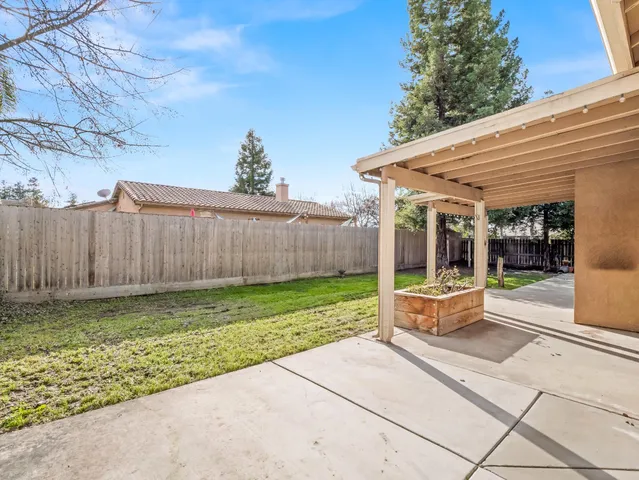 a view of a house with backyard and sitting area