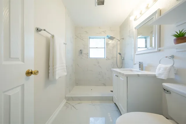 a bathroom with a sink toilet and shower