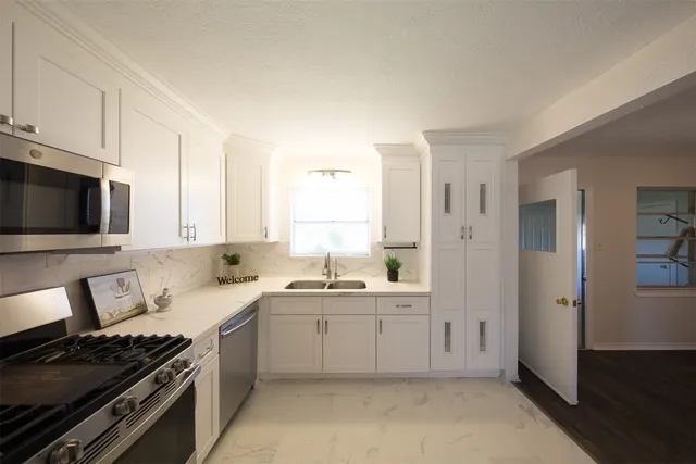 a kitchen with a sink stove and cabinets