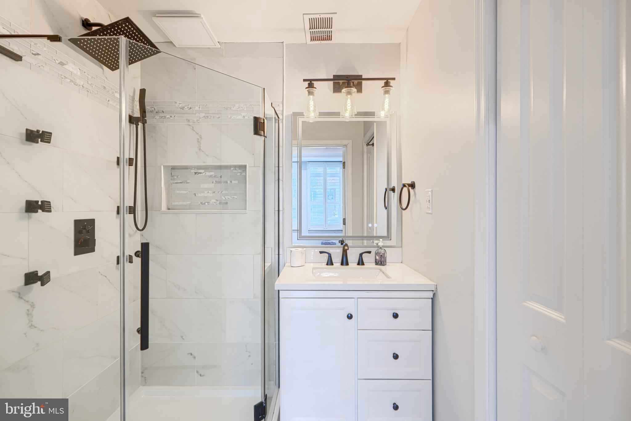 1309 Benjamin Street Baltimore, MD 21230 - Photo 11 of 60 a bathroom with a double vanity sink mirror and shower