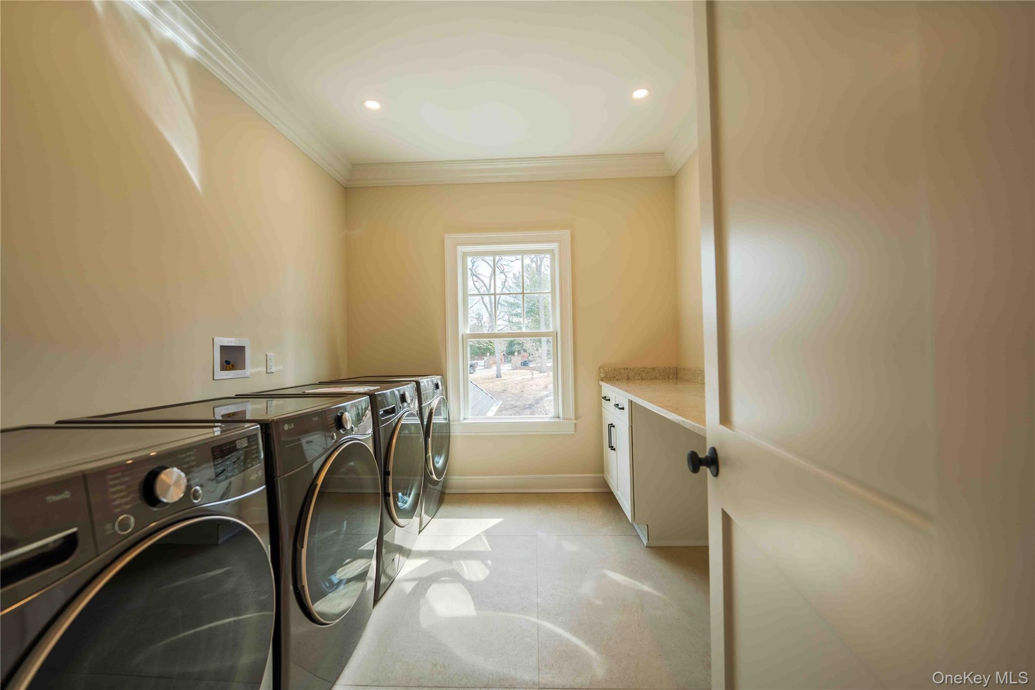 106 Cove Road Asharoken, NY 11768 - Photo 34 of 46 Laundry room with cabinet space, crown molding, washer and dryer, and recessed lighting