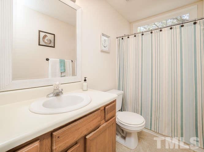 2312 Anihinga Court Raleigh, NC 27616 - Photo 16 of 25 a bathroom with a sink a toilet and shower curtain