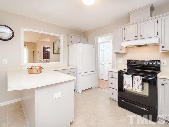 2312 Anihinga Court Raleigh, NC 27616 - Photo 4 of 25 a kitchen with a refrigerator and a stove top oven