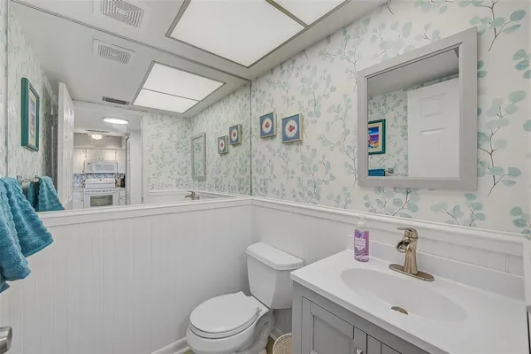 a bathroom with a sink mirror vanity and toilet