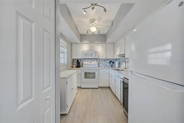 a kitchen with granite countertop a sink window and stainless steel appliances