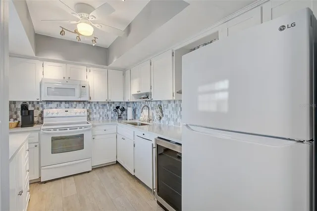 a kitchen with cabinets stainless steel appliances and a chandelier