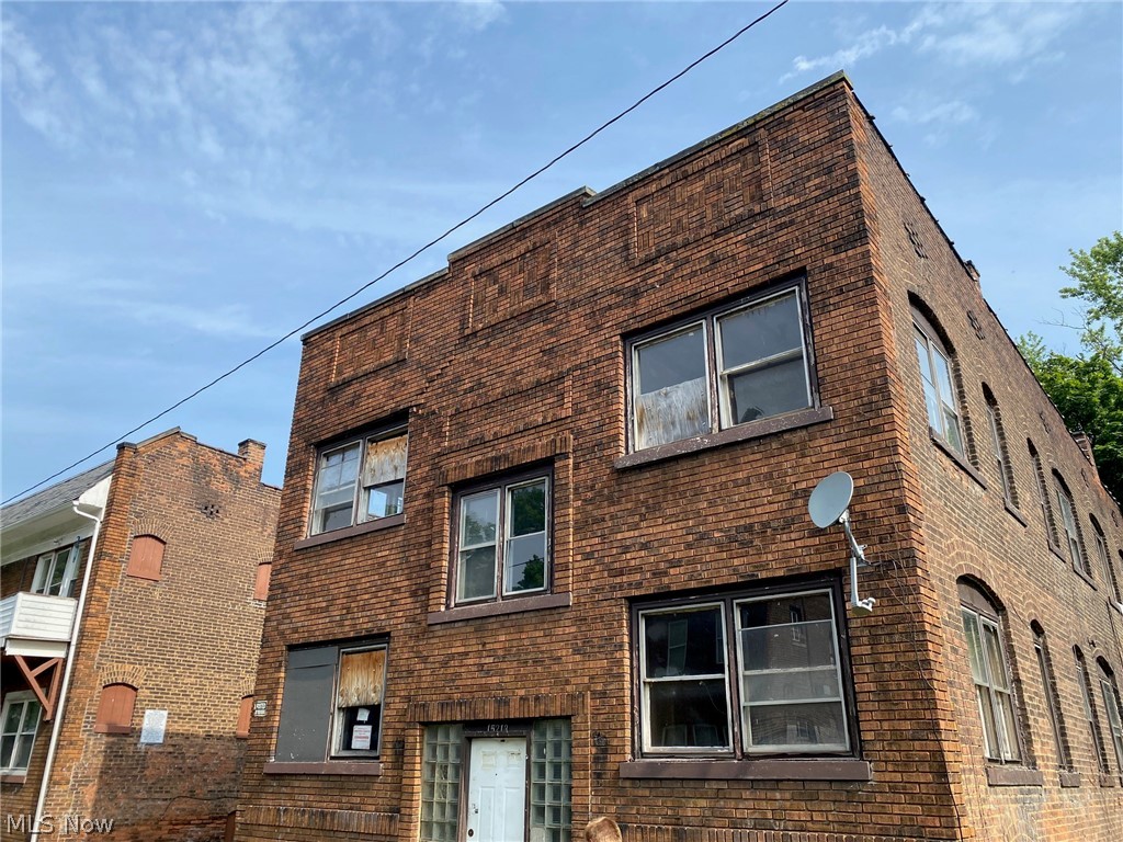 15213 Ridpath Avenue Cleveland, OH 44110 - Photo 1 of 25 Brick exterior featuring multiple windows and a glass block entry