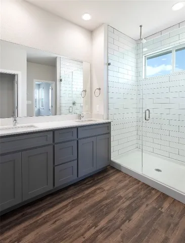 a bathroom with a double vanity sink mirror and shower