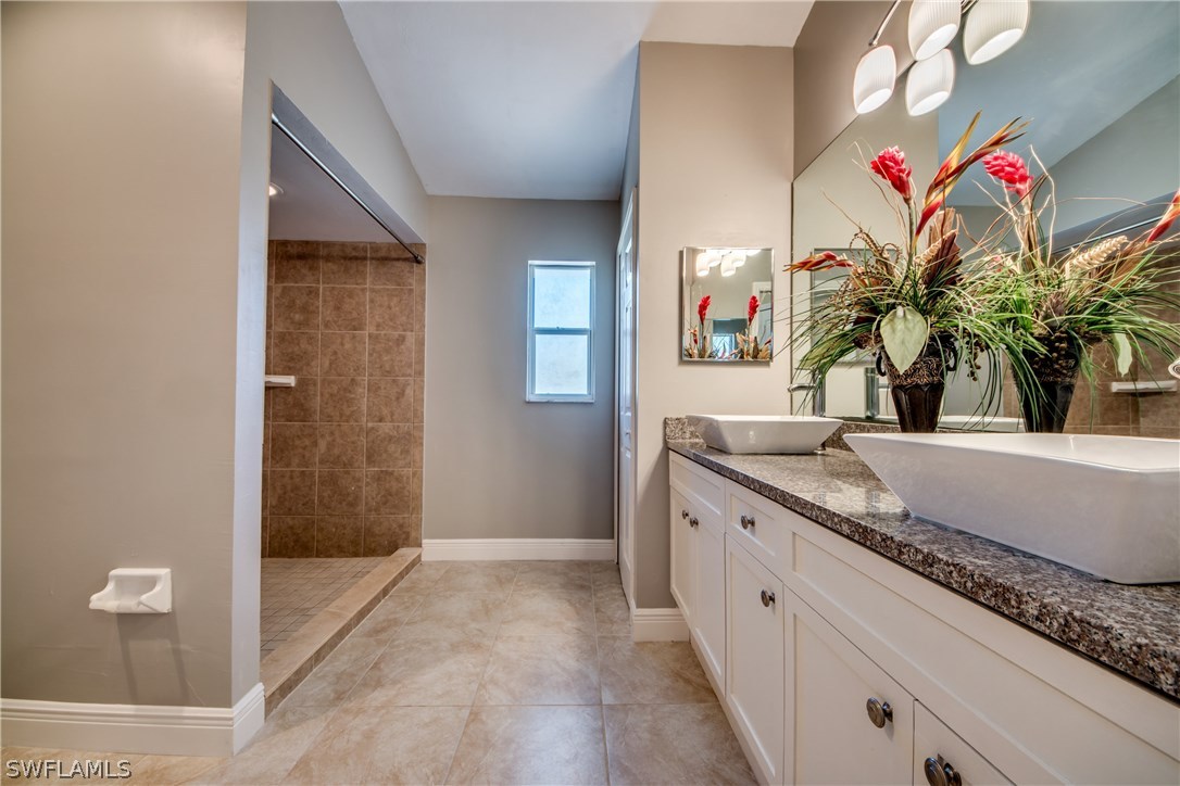 17517 Braddock Road Fort Myers, FL 33967 - Photo 21 of 33 a bathroom with a granite countertop sink a mirror and vanity
