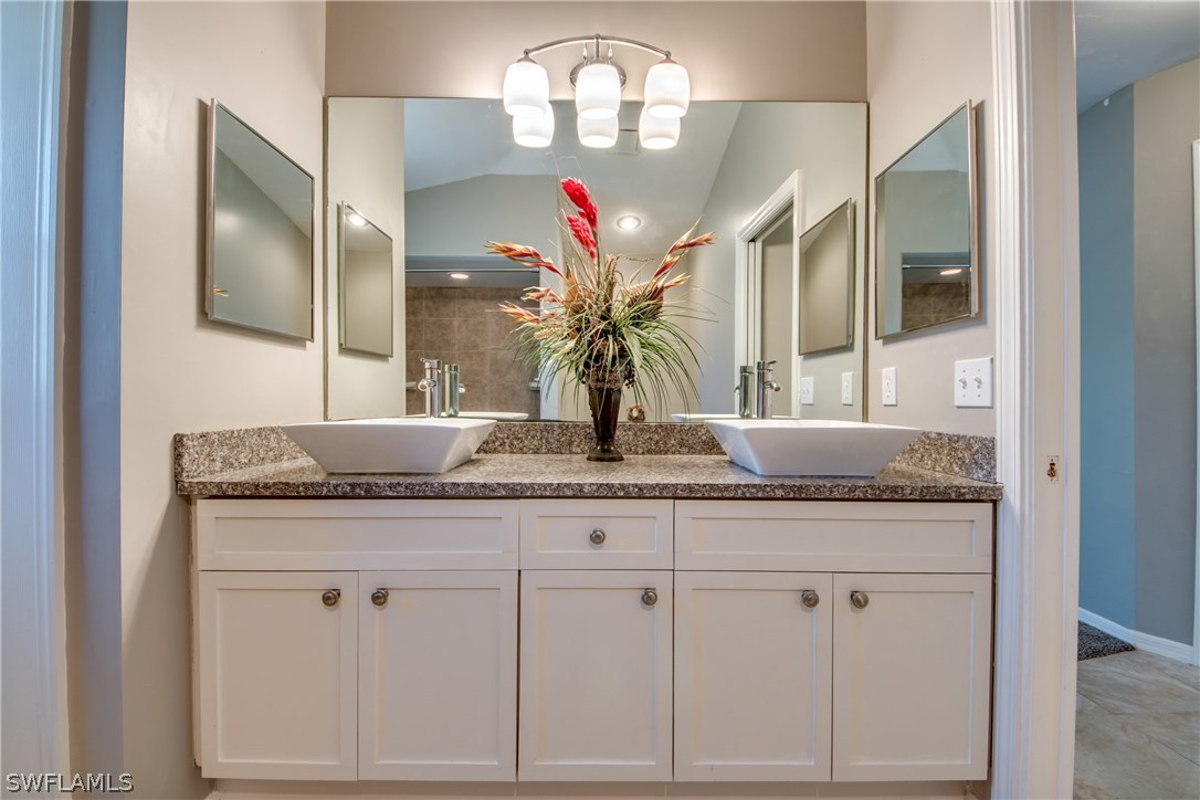 17517 Braddock Road Fort Myers, FL 33967 - Photo 22 of 33 a bathroom with a granite countertop double vanity and a mirror
