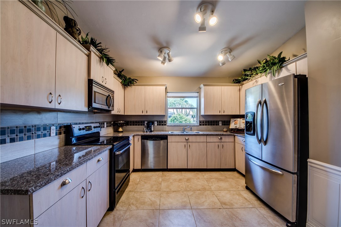 17517 Braddock Road Fort Myers, FL 33967 - Photo 3 of 33 a large kitchen with stainless steel appliances granite countertop a stove top oven a refrigerator a sink and dishwasher
