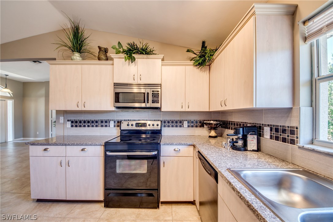 17517 Braddock Road Fort Myers, FL 33967 - Photo 5 of 33 a kitchen with stainless steel appliances granite countertop a sink and a stove