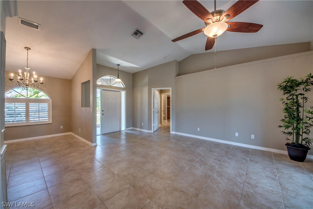 17517 Braddock Road Fort Myers, FL 33967 - Photo 10 of 33 an empty room with a chandelier fan and windows
