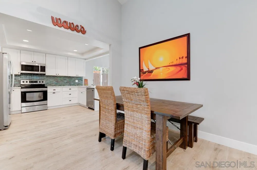 1955 Village Wood Road Encinitas, CA 92024 - Photo 11 of 31 a kitchen with stainless steel appliances kitchen island granite countertop a stove top oven a sink a dining table and chairs