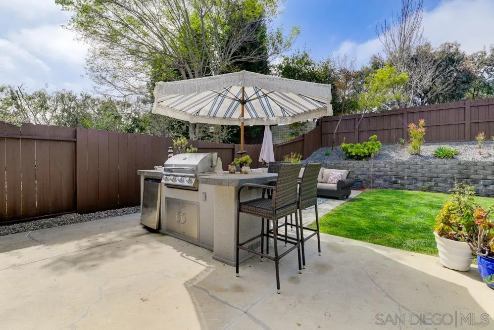 1955 Village Wood Road Encinitas, CA 92024 - Photo 19 of 31 a patio with a table and chairs under an umbrella