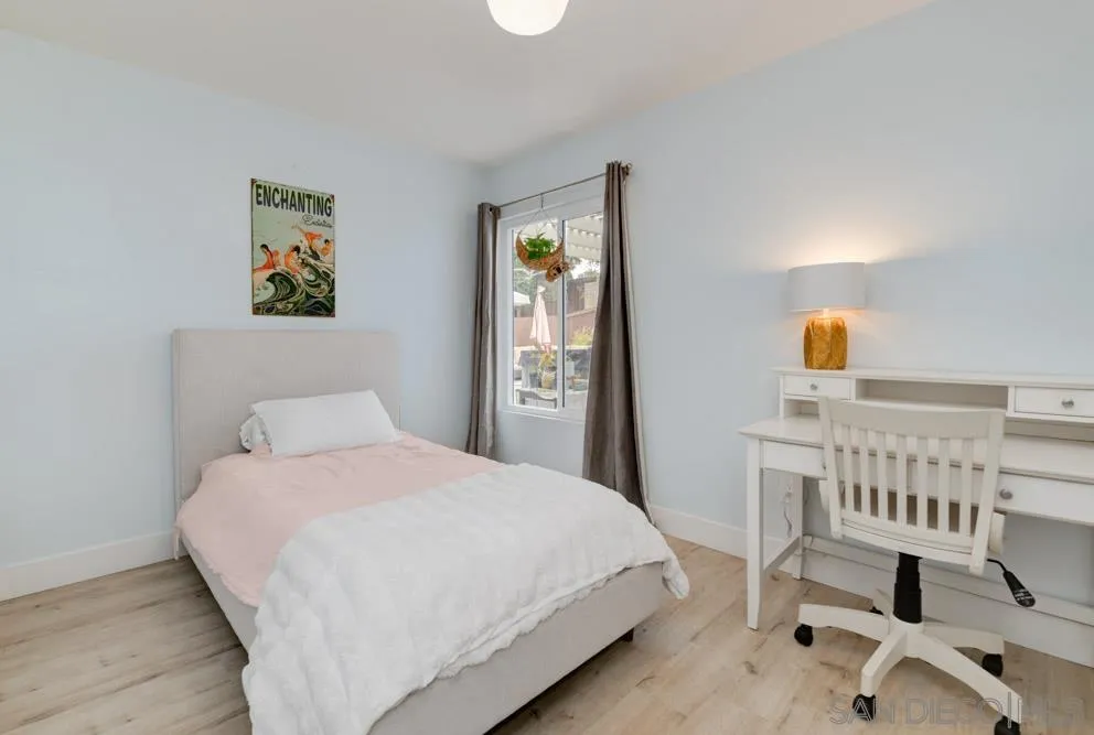 1955 Village Wood Road Encinitas, CA 92024 - Photo 27 of 31 a bedroom with a bed a mirror and lamp