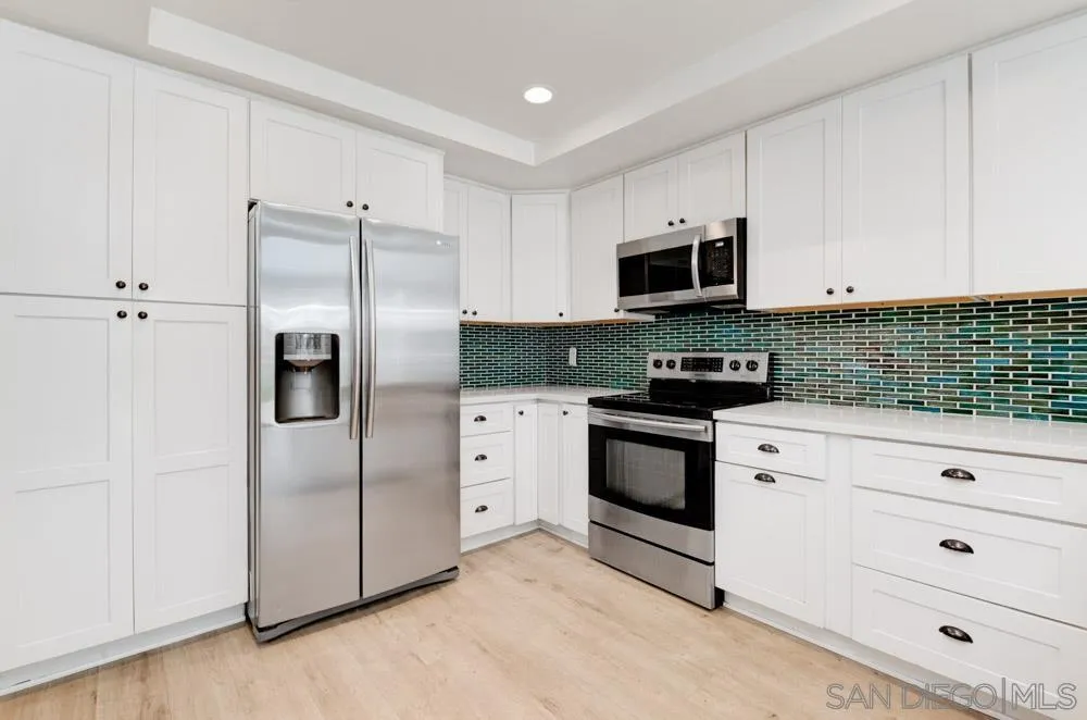 1955 Village Wood Road Encinitas, CA 92024 - Photo 8 of 31 a kitchen with stainless steel appliances white cabinets and a refrigerator