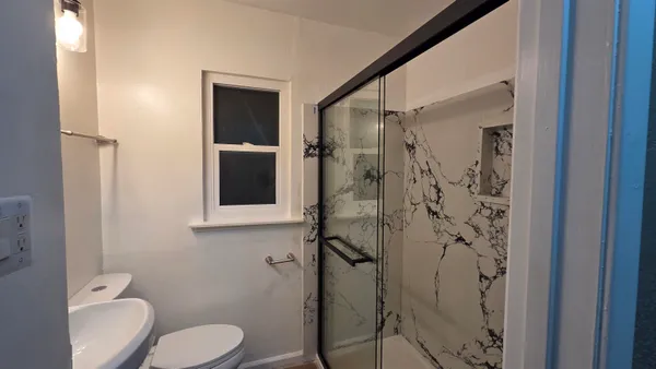 a bathroom with a toilet and a shower