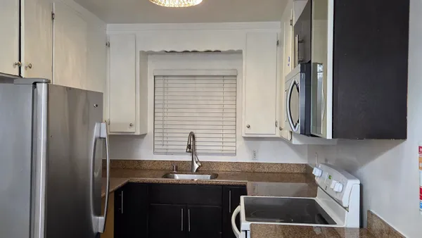 a kitchen with stainless steel appliances a sink stove and refrigerator