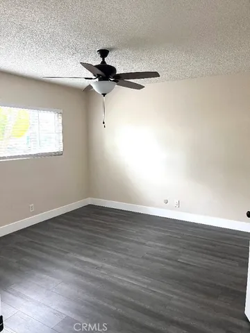 an empty room with wooden floor a ceiling fan