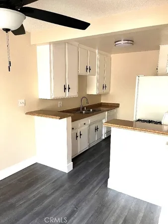 a view of kitchen with stainless steel appliances wooden floor and window