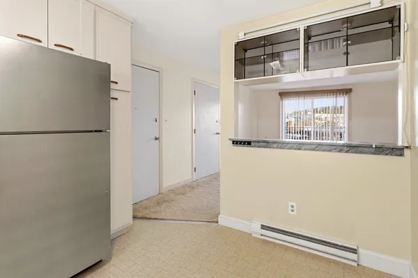 a view of a kitchen with refrigerator and window