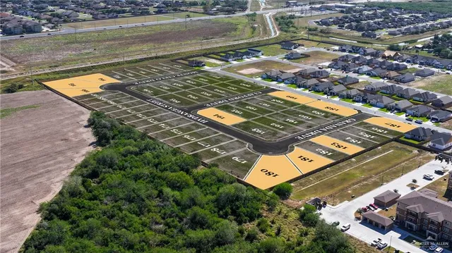 an aerial view of a residential houses with outdoor space and ocean view
